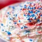 Bowl of Red White and Blue Cake Batter Dip with colorful sprinkles