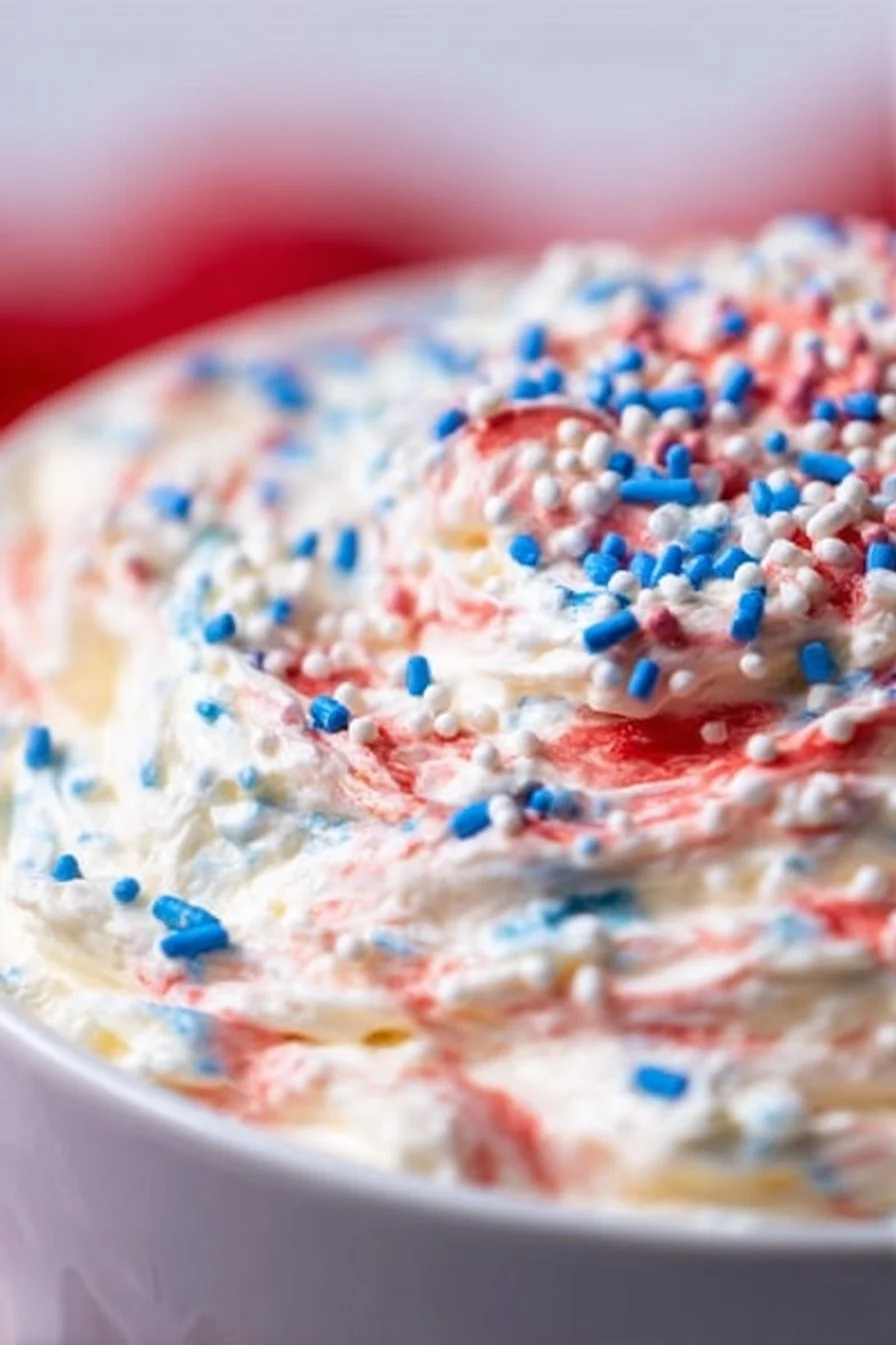 Bowl of Red White and Blue Cake Batter Dip with colorful sprinkles
