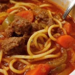 Slow-Cooker Spaghetti and Beef Soup in a bowl with herbs