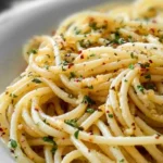 Plate of spaghetti with garlic and oil garnished with parsley