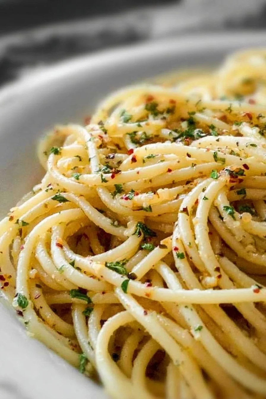 Plate of spaghetti with garlic and oil garnished with parsley
