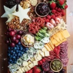 Stylish charcuterie board featuring gourmet snacks for a 4th of July celebration.