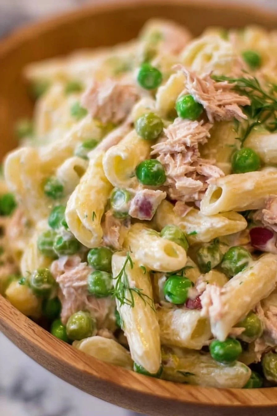 Bowl of tuna pasta salad with vegetables, herbs, and dressing