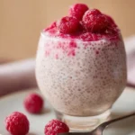 Vanilla Raspberry Chia Pudding in a glass bowl with fresh raspberries