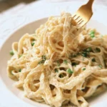 Vegan Cashew Alfredo pasta topped with herbs and spices for a delicious meal