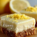 Zesty lemon cream cheese bars on a plate, garnished with lemon slices.